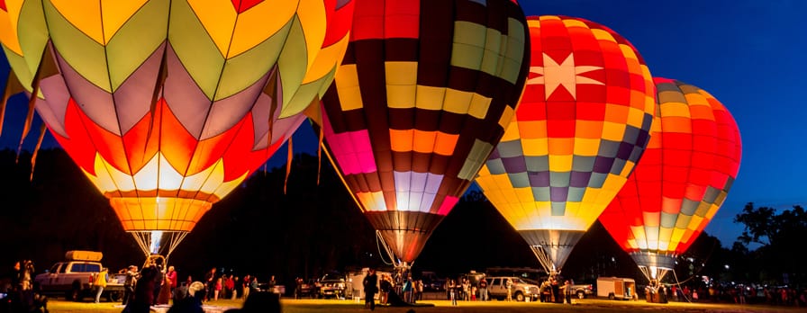 Four hot air balloons preparing to rise in the early morning dawn